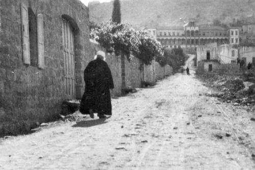 Þessi mynd frá árinu 1920 er af 'Abdu'l-Bahá þar sem Hann gengur frá húsi sínu í við Haparsim Street í Haifa. Hann vann sleitulaust að heimsfriði og að velferð og öryggi íbúanna í 'Akká og Haifa. 