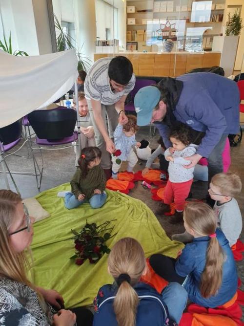 Foreldrar aðstoða börn sín á Ridvánhátíðinni sem haldin var í þjóðarmiðstöðinni