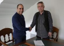 Róbert Badí Baldursson fulltrúi Andlegs þjóðarráðs bahá'ía á Íslandi (til vinstri) tekur í hendi Bjarna Harðarsonar bókaútgefanda (til hægri) við undirritun samnings um útgáfu á smásögum Skugga.